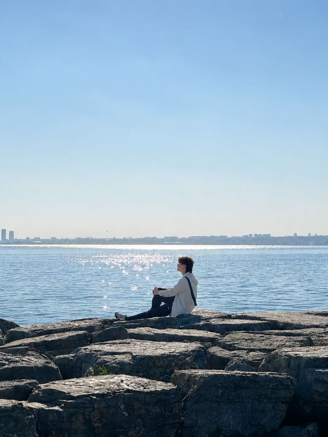 Yansen Wang sitting beside a lake
